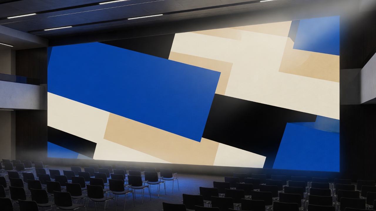 A modern conference hall with a large LED wall of abstract cobalt, bone, and black geometry.
